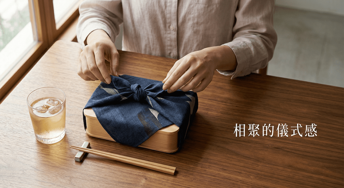 聚焦在「準備開動」的瞬間。一張充滿溫潤質感的木桌上,放著一個以日式風呂敷(質感包裹布)或極簡紙封條包裝的木製餐盒。畫面中有一雙穿著質感襯衫的手,正優雅地準備解開布包的繩結。旁邊點綴著一杯晶瑩剔透的冷泡高山茶。畫面不直接露出食物,而是營造出令人期待的「拆箱儀式感」。